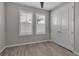 Neutral bedroom featuring wood-look tile floors, plantation shutters, and double door closet at 4869 Antrim Dr, Sarasota, FL 34240