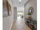Hallway with decorative mirror, console table, wood-look tile flooring, and view of the living area at 4869 Antrim Dr, Sarasota, FL 34240