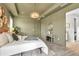 Olive-painted main bedroom with wood floors and a decorative chandelier and wall hangings at 4869 Antrim Dr, Sarasota, FL 34240