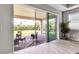Indoor/outdoor living area with sliding glass doors leading to brick patio, seating, and a hanging swing at 4869 Antrim Dr, Sarasota, FL 34240