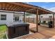A backyard view showcasing a hot tub, pergola, and comfortable bench seating at 4920 69Th N St, St Petersburg, FL 33709