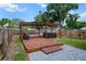 Backyard view showcasing a wooden deck, pergola, hot tub and bench seating at 4920 69Th N St, St Petersburg, FL 33709
