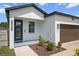 A modern home's front exterior boasts a dark-colored door, lush landscaping, and a two-car garage at 4920 69Th N St, St Petersburg, FL 33709