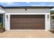 The home has a two-car garage with a dark brown door and modern exterior lighting at 4920 69Th N St, St Petersburg, FL 33709