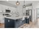 Modern kitchen features stainless steel appliances, a spacious island with seating, and stylish pendant lighting at 4920 69Th N St, St Petersburg, FL 33709