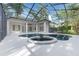 A covered, screened-in pool and spa area, complete with a private, lush backyard and access to the home at 5103 Twin Creeks Dr, Valrico, FL 33596