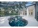Screened-in pool and spa in lush backyard offers private outdoor living and blends seamlessly with landscaping at 5103 Twin Creeks Dr, Valrico, FL 33596