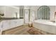 Modern bathroom featuring a glass block window, jetted tub, and a granite countertop at 5103 Twin Creeks Dr, Valrico, FL 33596