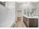 Bathroom featuring a dual sink vanity, wood drawers, and a shower/tub combo at 5103 Twin Creeks Dr, Valrico, FL 33596