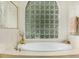 Bright bathroom featuring a jetted tub and glass block window at 5103 Twin Creeks Dr, Valrico, FL 33596