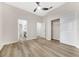 Bedroom with wood-look floors features a ceiling fan, closet, and bathroom access at 5103 Twin Creeks Dr, Valrico, FL 33596