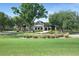 Beautiful clubhouse with lush green grass, manicured landscaping, and mature trees at 5103 Twin Creeks Dr, Valrico, FL 33596