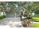 Beautiful one story home with a red front door, lush landscaping and a two car garage at 5103 Twin Creeks Dr, Valrico, FL 33596