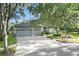 Charming home with a three-car garage, well-manicured landscaping, and a spacious driveway at 5103 Twin Creeks Dr, Valrico, FL 33596