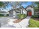 This house has a two car garage and a red front door with a paved walkway leading to it at 5103 Twin Creeks Dr, Valrico, FL 33596