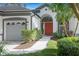Close up of a house featuring a red front door and a well manicured green lawn at 5103 Twin Creeks Dr, Valrico, FL 33596