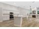 Bright, open-concept kitchen with stainless steel appliances, white cabinetry, and an island at 5103 Twin Creeks Dr, Valrico, FL 33596