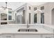 Kitchen island with stainless steel sink overlooking bright windows and dining area at 5103 Twin Creeks Dr, Valrico, FL 33596