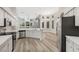 A well-lit kitchen featuring stainless steel appliances, light countertops, and wood-look flooring at 5103 Twin Creeks Dr, Valrico, FL 33596