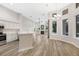 Spacious living room with a fireplace, tall windows, and kitchen view at 5103 Twin Creeks Dr, Valrico, FL 33596