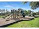 Fun playground featuring slides and structures, with a safe mulch ground and surrounding grass at 5103 Twin Creeks Dr, Valrico, FL 33596