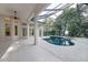 Large screened-in pool and spa area with ceiling fan and access to the home's interior through french doors at 5103 Twin Creeks Dr, Valrico, FL 33596
