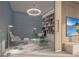 Stylish home office with a glass desk, decorative lighting, built-in shelving, and a scenic view on TV at 555 Quay Cmn # 2004, Sarasota, FL 34236