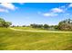 Scenic backyard featuring a lush green lawn and peaceful lake views on a clear day at 5609 Spanish Point Ct, Palmetto, FL 34221