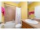 Cozy full bathroom featuring a shower-tub combo, vanity and vibrant yellow walls at 5609 Spanish Point Ct, Palmetto, FL 34221