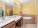 Bathroom with double sinks, large mirror, and soaking tub at 5609 Spanish Point Ct, Palmetto, FL 34221