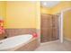 Bathroom featuring a soaking tub and tiled shower with a glass enclosure at 5609 Spanish Point Ct, Palmetto, FL 34221