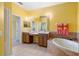Bathroom with dual sinks, vanity, a soaking tub, and decorative tile at 5609 Spanish Point Ct, Palmetto, FL 34221