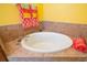 Large soaking tub in a bathroom with tiled surround and decorative towels at 5609 Spanish Point Ct, Palmetto, FL 34221