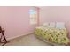 Comfortable bedroom with floral bedding, window and a bright pink wall at 5609 Spanish Point Ct, Palmetto, FL 34221