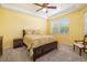Bright bedroom featuring a ceiling fan, large window, and neutral carpeting at 5609 Spanish Point Ct, Palmetto, FL 34221