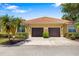 Beautiful home featuring a tile roof, two-car garage, and mature landscaping at 5609 Spanish Point Ct, Palmetto, FL 34221