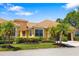 Lovely home with lush tropical landscaping, a tile roof, and a well-manicured lawn at 5609 Spanish Point Ct, Palmetto, FL 34221