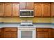 Classic kitchen featuring wooden cabinetry, essential appliances, and a practical design for cooking at 5609 Spanish Point Ct, Palmetto, FL 34221