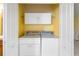 Convenient laundry room with a white washer and dryer and overhead storage at 5609 Spanish Point Ct, Palmetto, FL 34221