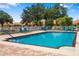Community pool with clear blue water surrounded by lounge chairs at 5609 Spanish Point Ct, Palmetto, FL 34221
