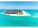 A panoramic aerial view showcasing a coastal community surrounded by clear turquoise water and sandy beaches at 5806 Gulf Dr # 201, Holmes Beach, FL 34217