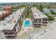 Stunning aerial view of beachfront condos with a sparkling pool and lush landscaping at 5806 Gulf Dr # 201, Holmes Beach, FL 34217