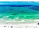 A stunning view of clear turquoise water and a white sand beach with scattered beachgoers enjoying the sun at 5806 Gulf Dr # 201, Holmes Beach, FL 34217