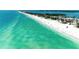 Breathtaking aerial view showcasing a wide sandy beach with clear, turquoise water meeting the shoreline at 5806 Gulf Dr # 201, Holmes Beach, FL 34217