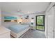 Inviting bedroom with a cozy bed, beach-themed artwork, and a sunny window view of lush greenery at 5806 Gulf Dr # 201, Holmes Beach, FL 34217