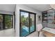 A stylish dining room area features a chandelier, built-in shelving and balcony access at 5806 Gulf Dr # 201, Holmes Beach, FL 34217