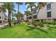 Attractive condo exterior with lush green lawn, mature palm trees, and vibrant landscaping, creating an inviting tropical setting at 5806 Gulf Dr # 201, Holmes Beach, FL 34217