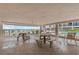 Beachfront patio area with multiple picnic tables and ocean views, perfect for relaxing and enjoying the seaside atmosphere at 5806 Gulf Dr # 201, Holmes Beach, FL 34217