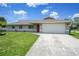 Well-maintained home featuring a lush lawn, driveway, and a two-car garage at 590 Ridgewood Nw St, Port Charlotte, FL 33952