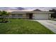 Charming single-story home with lush lawn, landscaping, and a two-car garage at 590 Ridgewood Nw St, Port Charlotte, FL 33952
